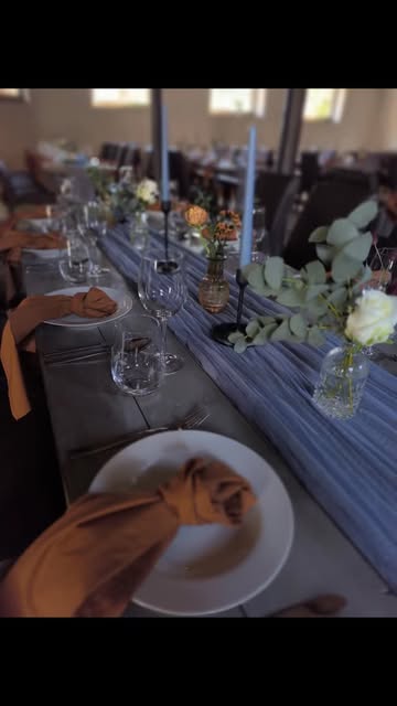 Lange Hochzeitstafel mit Terrakotta-Servietten und staubblauen Stabkerzen